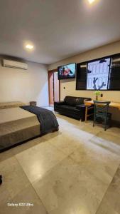 une chambre avec un lit et une télévision à écran plat dans l'établissement Studio Astral, à Uberlândia