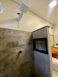 La salle de bains est pourvue d'une douche et d'une lumière au plafond. dans l'établissement Studio Astral, à Uberlândia 10 autres photos