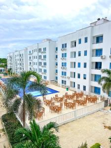 a hotel with tables and chairs in front of a building at Acogedor apto en Coveñas 301 in Coveñas