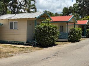 ein kleines Haus mit rotem Dach neben einer Straße in der Unterkunft Barrier Reef Tourist Park in Edmonton + 2 Fotos