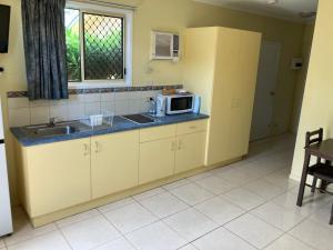 eine Küche mit Spüle und Mikrowelle in der Unterkunft Barrier Reef Tourist Park in Edmonton