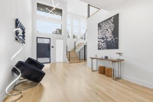 un soggiorno bianco con una sedia nera e delle scale di Upscale Modern Living - 4BD 4BA Backyard & Cinema a Oldham