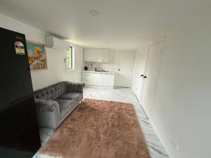 uma sala de estar com um sofá e uma cozinha em 2bed granny flat close to Auckland Airport em Auckland mais 12 fotografias