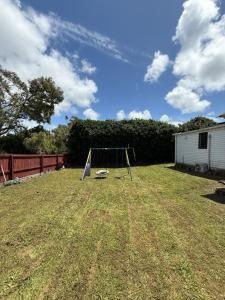 um baloiço no meio de um quintal em 2bed granny flat close to Auckland Airport em Auckland