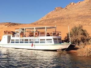 un bateau sur l'eau devant une montagne dans l'établissement Nubiana Boat, 
