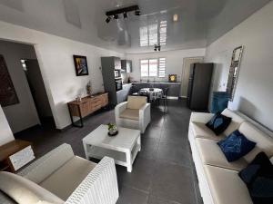 Una sala de estar con sofás blancos y una mesa. en Maeva I Papara, en Papara