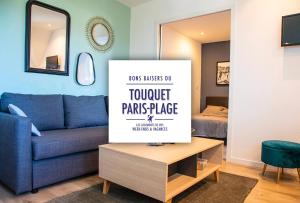 a living room with a blue couch and a table at Résidence grand jardin attenant tennis, mini golf, sauna, pétanque in Stella-Plage
