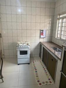 eine kleine Küche mit Herd und Spüle in der Unterkunft Casa espaçosa e confortável perto do Aeroporto in Sao Jose do Rio Preto
