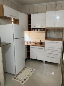 eine Küche mit einem weißen Kühlschrank und weißen Schränken in der Unterkunft Casa espaçosa e confortável perto do Aeroporto in Sao Jose do Rio Preto