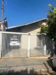 ein weißer Zaun mit einem dahinter geparkten Auto in der Unterkunft Casa espaçosa e confortável perto do Aeroporto in Sao Jose do Rio Preto