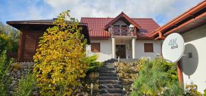 une maison avec un panneau devant dans l'établissement Domki nad jeziorem Ostoja Głuszyńska, à Potołówek