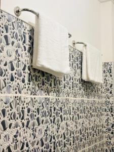 a bathroom with white towels and a shower curtain at Muthumala Villa in Tangalle +23 photos