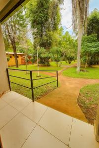 a porch with a fence in a park at Complejo de Apartamentos parque naturaleza in Encarnación +1 photo