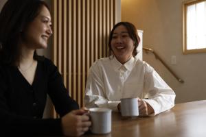 two women sitting at a table with coffee cups at 晴レ吉 in Fukuoka