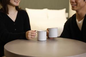 two women sitting at a table with coffee cups at 晴レ吉 in Fukuoka