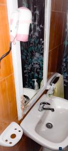 a bathroom with a sink and a mirror at Hospedaje Los Buenos Aires in Santa Ana