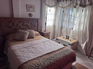 une chambre avec un grand lit et une fenêtre dans l'établissement "Kalula" Casa de Campo en Raco, à Siambón
