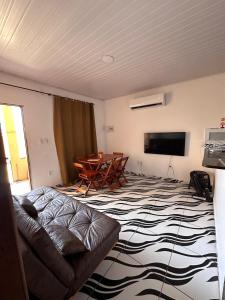 a living room with a couch and a table at Casa Sol & Mar in Arraial do Cabo