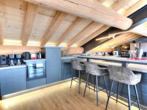 加尔米施-帕滕基兴Luxury Top Chalet - 1000 EUR damage deposit的一间带木制天花板的厨房和一间带凳子的酒吧 更多28张照片