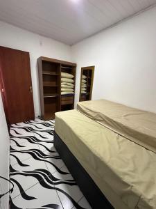 a bedroom with a bed and a zebra patterned floor at Casa Sol & Mar in Arraial do Cabo