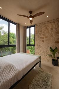 a bedroom with a bed and a ceiling fan at Your Refuge in the Mayan Jungle Cobá, 2 Bedrooms in Cobá
