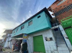 een blauw en groen gebouw met een groene garage bij Flat há 15 min da Pajuçara in Maceió
