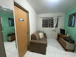 een woonkamer met een bank en een televisie bij Flat há 15 min da Pajuçara in Maceió