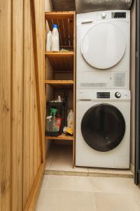a washer and dryer sitting in a room with at Villa privée - Piscine, Jacuzzi, Sauna & Hammam in Le Tampon