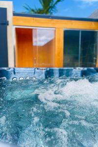 a pool of water in front of a house at Villa privée - Piscine, Jacuzzi, Sauna & Hammam in Le Tampon