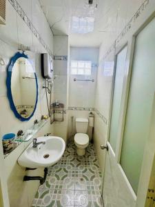 a bathroom with a white toilet and a sink at Ren Apartments in Ho Chi Minh City