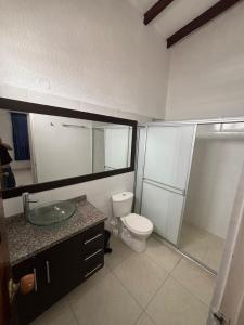 a bathroom with a toilet and a sink and a shower at Casa grande en el centro de Roldanillo in Roldanillo +15 photos