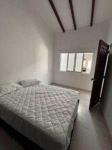 a bedroom with a bed in a white room at Casa grande en el centro de Roldanillo in Roldanillo