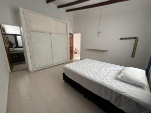 a bedroom with a bed and a large door at Casa grande en el centro de Roldanillo in Roldanillo