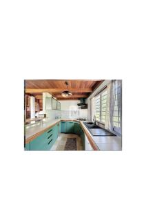 an image of a kitchen with blue cabinets at La mélodieuse in Macouria