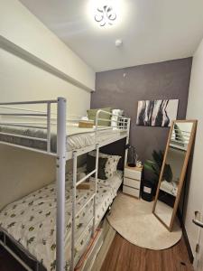 una camera con due letti a castello e uno specchio di Casa Celestine Staycation a Manila