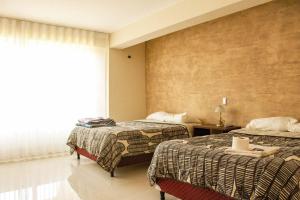 a hotel room with two beds and a window at Hotel Sky - Tarija in Tarija