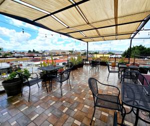 a patio with tables and chairs on a roof at Hotel del Refugio in Guadalajara