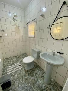 a bathroom with a toilet and a sink at Casa Gonzalez Oliveira in Mongaguá +20 photos