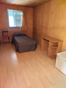 康塞普西翁Habitación individual para hombres `的一间有一张床和一张书桌的小房间