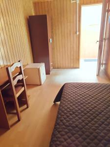 康塞普西翁Habitación individual para hombres `的一间卧室，配有一张床、一张桌子和一把椅子