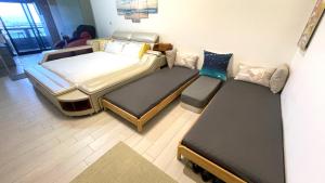 Zimmer mit 2 Betten, einem Bett und einem Sofa in der Unterkunft Ocean 海上玩家 景觀溫泉小館 in Toucheng