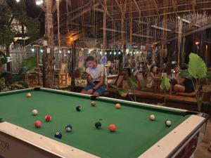 a man sitting next to a pool table at Wonderland in Siquijor