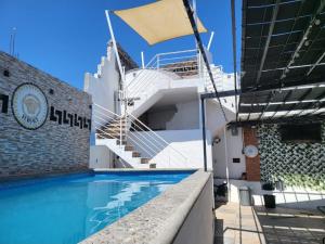 a swimming pool in front of a building with stairs at Casa Versace Tequesquitengo in Tequesquitengo
