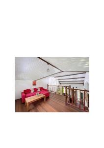 a living room with a red couch and a table at La mélodieuse in Macouria
