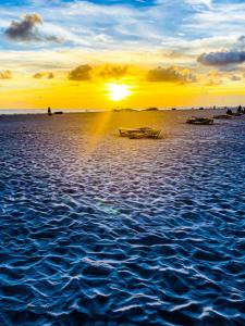 a sunset on the ocean with boats in the water at Waterfront Boat Lift Bungalow in St Pete Beach