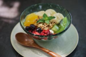 Un bol de fruta y frutos secos en un plato con una cuchara en Villa SACHIIBARU 浜辺の茶屋 の 宿, en Nanjō