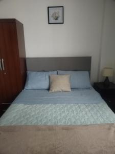 ein Bett mit blauer Bettwäsche und einem Kissen darauf in der Unterkunft Departamento Acogedor Céntrico en Huanchaco3B in Huanchaco