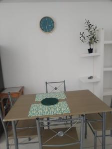 einen Tisch und Stühle mit einer Uhr an der Wand in der Unterkunft Departamento Acogedor Céntrico en Huanchaco3B in Huanchaco