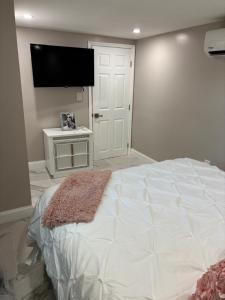 Un dormitorio con una cama grande y un televisor de pantalla plana. en Peace and Tranquility awaits, en Miami Gardens