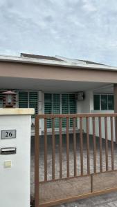 a house with a wooden fence and a gate at RC Homestay Permaipura in Bedung
